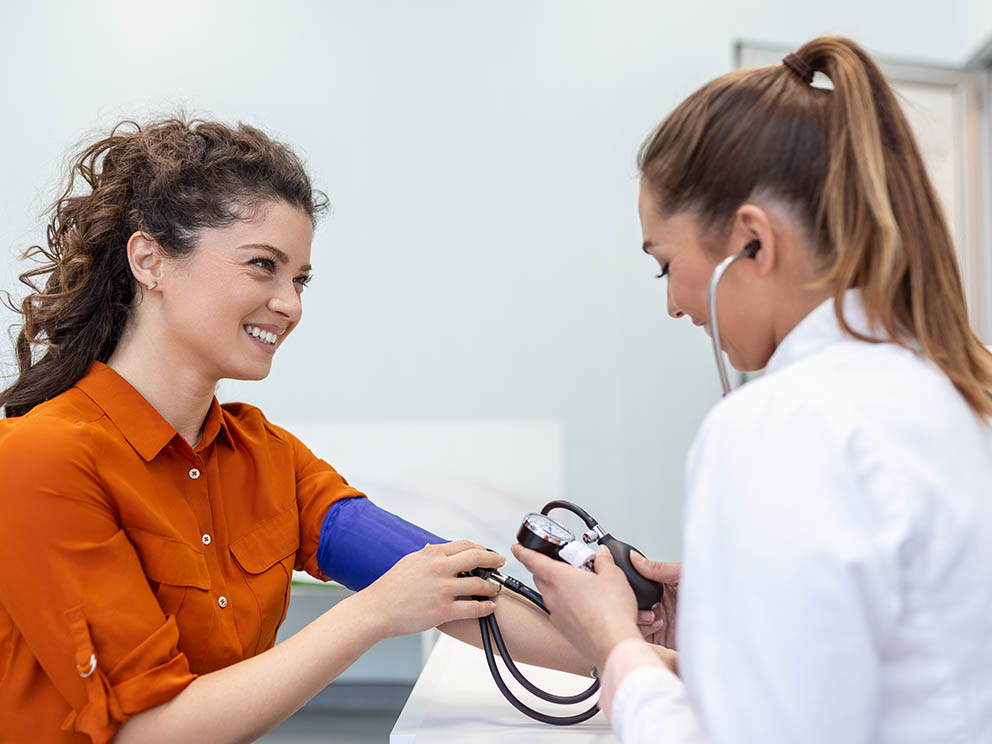 Nurse locating vein for blood draw.