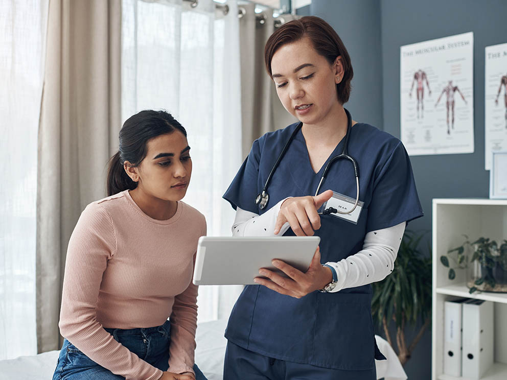 Team member helping a patient check in to his appointment.